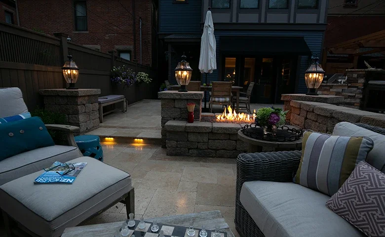 Outdoor seating and fireplace beside a pool